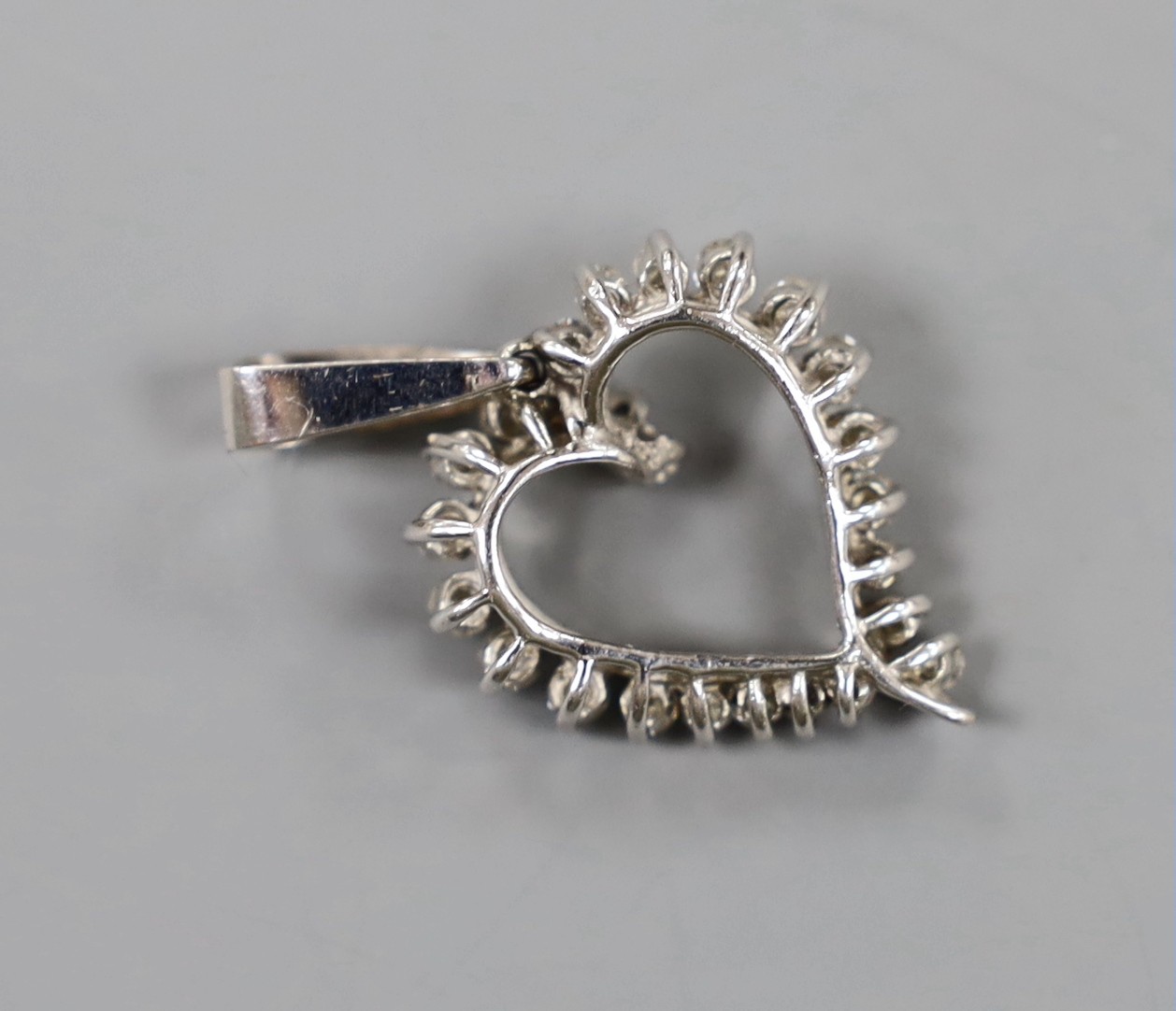 A white metal and diamond set open work heart pendant, overall 36mm, gross weight 4.8 grams.